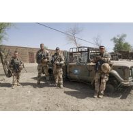 Portrait de soldats du régiment de marche du Tchad (RMT) devant l'épave d'un véhicule militaire dans la cour d'une caserne désaffectée des forces armées maliennes (FAMa) à Bitagoungou, au Mali.