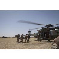 Des auxiliaires sanitaires évacuent un blessé par hélicoptère Caïman NH-90 dans la région de Bitagoungou, au Mali.