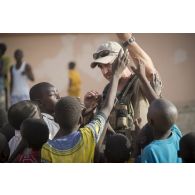 Un agent des actions civilo-militaires (CIMIC) prend contact avec des enfants de Bitagoungou, au Mali.