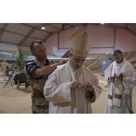 Un prévôt aide l'évêque aux armées  Antoine de Romanet de Beaune à se préparer à célébrer la messe de Noël à Niamey, au Niger.