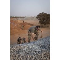 Des soldats franchissent un obstacle autour de la base aérienne de Niamey, au Niger.