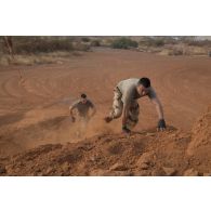Des soldats franchissent un obstacle autour de la base aérienne de Niamey, au Niger.