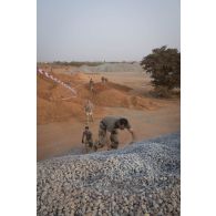 Des soldats franchissent un obstacle autour de la base aérienne de Niamey, au Niger.
