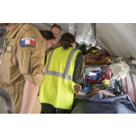 Des infirmières convoyeuses de l'air encadrent un blessé à bord d'un avion Casa Nurse sur la base aérienne de Niamey, au Niger.