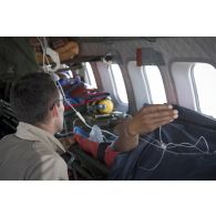 Un élément de la 4e antenne chirurgicale aérotransportable (ACP) veille sur un blessé à bord d'un avion Casa Nurse sur la base aérienne de Niamey, au Niger.