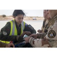 Une infirmière convoyeuse de l'air se coordonne avec des éléments de la 4e antenne chirurgicale aérotransportable (ACP) pour une évacuation sanitaire sur la base aérienne de Niamey, au Niger.