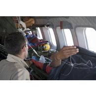 Un élément de la 4e antenne chirurgicale aérotransportable (ACP) veille sur un blessé à bord d'un avion Casa Nurse sur la base aérienne de Niamey, au Niger.