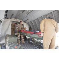 Des éléments de la 4e antenne chirurgicale aérotransportable (ACP) débarquent un blessé depuis un avion Casa Nurse sur la base aérienne de Niamey, au Niger.