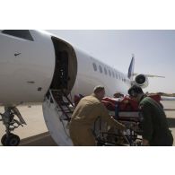 Des éléments de la 4e antenne chirurgicale aérotransportable (ACP) évacuent un blessé à bord d'un avion Falcon 2000 depuis Niamey, au Niger.