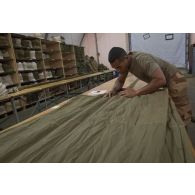 Le soldat de 1re classe Romain du 1er régiment du train parachutiste (RTP) met la voilure d'un parachute en position Sapin afin de retrouver le fuseau de référence à Niamey, au Niger.