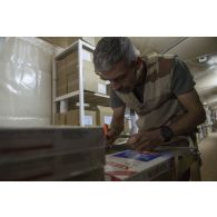 Le caporal-chef Jérôme de l'unité de distribution des produits de santé (UDPS) prépare une commande de médicaments à la pharmacie centrale de Niamey, au Niger.