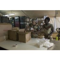 La préparatrice en pharmacie Fatou et le caporal-chef Jérôme de l'unité de distribution des produits de santé (UDPS) préparent une commande de médicaments à la pharmacie centrale de Niamey, au Niger.