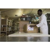 L'agent civil Mamadou de l'unité de distribution des produits de santé (UDPS) prépare une commande de médicaments à la pharmacie centrale de Niamey, au Niger.