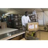 L'agent civil Mamadou de l'unité de distribution des produits de santé (UDPS) prépare une commande de médicaments à la pharmacie centrale de Niamey, au Niger.
