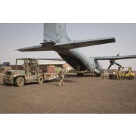 Des soldats du détachement de transit interarmées (DéTIA) chargent du fret à bord d'un avion Transall C-160 à Gao, au Mali.
