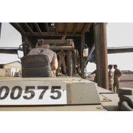 Des soldats du détachement de transit interarmées (DéTIA) chargent du fret à bord d'un avion Transall C-160 à Gao, au Mali.
