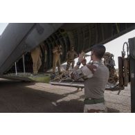 Des membres d'équipage d'un avion Transall C-160 aident au chargement de fret par le détachement de transit interarmées (DéTIA) dans la soute de son appareil à Gao, au Mali.
