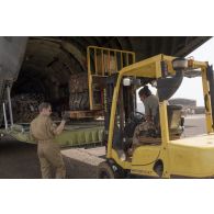 Des membres d'équipage d'un avion Transall C-160 aident au chargement de fret par le détachement de transit interarmées (DéTIA) dans la soute de son appareil à Gao, au Mali.