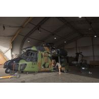 Des mécaniciens interviennent sur un hélicoptère Caïman NH-90 TTH pour sa remise en configuration opérationnelle à Niamey, au Niger.