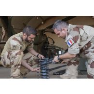 Des armuriers contrôlent les obus de 30 mm du canon 781 d'un hélicoptère Tigre EC-665 HAD pour sa remise en capacité opérationnelle à Niamey, au Niger.