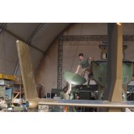 Des mécaniciens interviennent sur le rotor principal d'un hélicoptère Tigre EC-665 HAD pour sa remise en capacité opérationnelle à Niamey, au Niger.