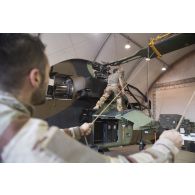 Des mécaniciens interviennent sur le rotor principal d'un hélicoptère Tigre EC-665 HAD pour sa remise en capacité opérationnelle à Niamey, au Niger.