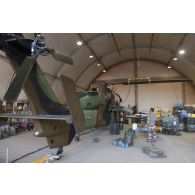 Des mécaniciens interviennent sur le rotor principal d'un hélicoptère Tigre EC-665 HAD pour sa remise en capacité opérationnelle à Niamey, au Niger.