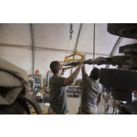 Des mécaniciens interviennent sur le rotor principal d'un hélicoptère Tigre EC-665 HAD pour sa remise en capacité opérationnelle à Niamey, au Niger.