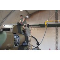 Des mécaniciens interviennent sur le rotor principal d'un hélicoptère Tigre EC-665 HAD pour sa remise en capacité opérationnelle à Niamey, au Niger.