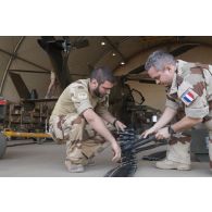 Des armuriers contrôlent les obus de 30 mm du canon 781 d'un hélicoptère Tigre EC-665 HAD pour sa remise en capacité opérationnelle à Niamey, au Niger.