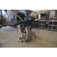 Des mécaniciens contrôlent le canon 781 de 30 mm d'un hélicoptère Tigre EC-665 HAD pour sa remise en capacité opérationnelle à Niamey, au Niger.