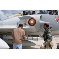 Avant le départ en mission, un pilote qatari effectue la visite de contrôle avant vol de son avion Mirage 2000-5 QA 85 avec son mécanicien de piste.