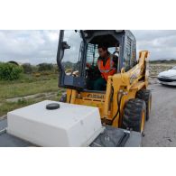 Un conducteur aux commandes d'un engin du génie grec GEHL.