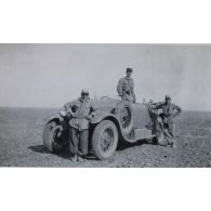 [Trois militaires et une automobile dans un désert syrien].