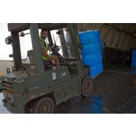 Déchargement de palettes de pneus de la soute d'un avion-cargo de transport Antonov 225 ukrainien par un engin de manutention transpalette OM du RTP (régiment du train parachutiste).