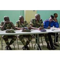 Dans une salle de formation, des stagiaires sénégalais écoutent le cours et prennent des notes.
