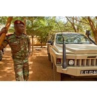 Portrait d'un capitaine béninois devant un pick-up ACMAT 4x4 du Bénin ALTV (véhicule tactique léger) avec schnorchel Donaldson Top Spin.