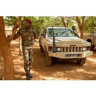 Portrait d'un capitaine béninois devant un pick-up ACMAT 4x4 du Bénin ALTV (véhicule tactique léger) avec schnorchel Donaldson Top Spin.