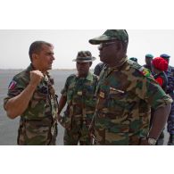 Un capitaine français, officier de liaison de la coopération opérationnelle régionale, discute avec le colonel togolais K. Karka en présence d'un lieutenant togolais sur l'aéroport de Bamako.