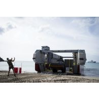 Un sapeur du 17e régiment du génie parachutiste (RGP) guide le débarquement d'un engin du génie rapide de protection (EGRAP) depuis un engin de débarquement amphibie rapide (EDAR) sur l'île de Saint-Martin, aux Antilles.