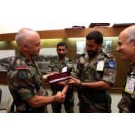 Un colonel remet un cadeau à un officier émirati.