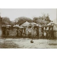 [Une colonne de porteurs traverse un village, s. d.]