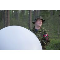 Un artilleur canadien gonfle un ballon sonde pour un relevé météorologique au camp de Pabradé, en Lituanie.