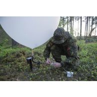 Un artilleur canadien prépare un ballon sonde pour un relevé météorologique au camp de Pabradé, en Lituanie.
