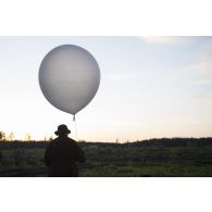 Un artilleur canadien effectue un relevé météorologique au moyen d'un ballon sonde au camp de Pabradé, en Lituanie.