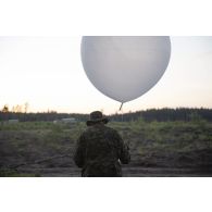 Un artilleur canadien effectue un relevé météorologique au moyen d'un ballon sonde au camp de Pabradé, en Lituanie.