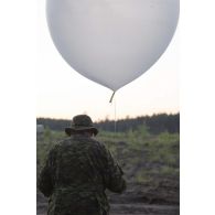 Un artilleur canadien effectue un relevé météorologique au moyen d'un ballon sonde au camp de Pabradé, en Lituanie.