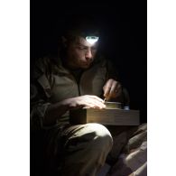 Un mécanicien du Service des essences des armées (SEA) mange sa ration de combat en bivouac à Madama, au Niger.