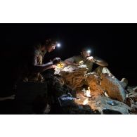 Les brigadiers-chef Jean et Nicolas du Service des essences des armées (SEA) mangent leur ration de combat en bivouac à Madama, au Niger.