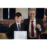 Portrait de monsieur Jean Pruvost, lexicologue, en compagnie d'un lauréat lors de la remise des prix du Plumier d'or au pavillon de musique de la Maison d'éducation de la Légion d'honneur à Saint-Denis.